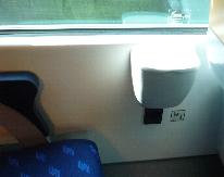 座席の窓側の壁には、電源ソケットがありました。その上に見えるのはごみ入れです。